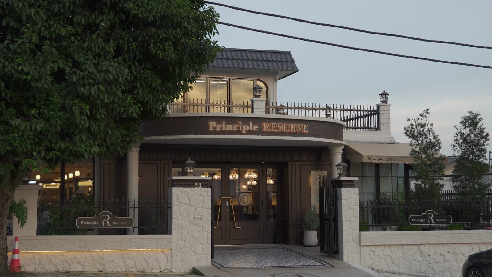Principle Reserve shopfront at dusk, with its arched sign above number 23